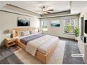 Bright and airy main bedroom features a tray ceiling, a ceiling fan, and three large windows at 3671 Salvia Dr, Buford, GA 30519