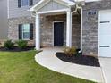 Front entrance of home with brick accents, landscaping, and a covered porch at 117 Oliver Dr, Locust Grove, GA 30248