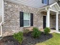 Close up view of the front entrance with brick accents and landscaping at 117 Oliver Dr, Locust Grove, GA 30248