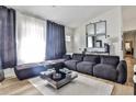 A modern living room boasts a large sectional sofa, stylish decor, and plenty of natural light at 3915 Basil Sw Way, Atlanta, GA 30331