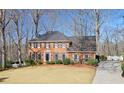 Classic brick home featuring a well-manicured lawn and a long driveway leading to the residence at 4055 River Cliff Chase Se, Marietta, GA 30067
