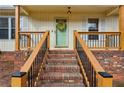 Charming front porch with brick steps and a decorative wreath adorning the front door at 2441 Hidden Hills Dr, Marietta, GA 30066