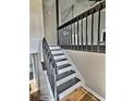 A staircase features dark wood railings and white risers, complemented by wood floors and neutral-colored walls at 5550 Mccrossin Cir, Stonecrest, GA 30038