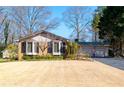 Well-maintained home with bay window, complemented by lush landscaping, mature trees, and a two-car garage at 1341 Longwood Sw Dr, Marietta, GA 30008