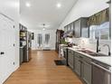 Modern kitchen with sleek gray cabinetry, stainless steel appliances, and wood-look flooring at 1760 Campbell Ives Dr, Lawrenceville, GA 30045