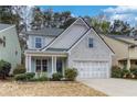 Charming home featuring a brick and shingle facade, well-manicured landscaping, and a two-car garage at 264 Ascott Ln, Woodstock, GA 30189