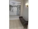 A comfy bench sits below an eye-catching piece of artwork in this neutrally painted hallway at 3280 Stillhouse Se Ln # 101, Atlanta, GA 30339