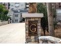 Close-up of 'The Greystone' signage in front of a building and stone wall with trees on the side at 3280 Stillhouse Se Ln # 101, Atlanta, GA 30339