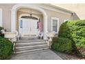 Elegant entryway with a white arched doorway, decorative urns, and an American flag at 9390 Knollcrest, Alpharetta, GA 30022
