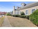 Attractive home showcasing its architectural design, complemented by manicured shrubs and a green lawn at 9390 Knollcrest, Alpharetta, GA 30022