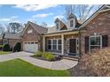 Lovely brick home with two-car garage, manicured lawn, and charming details such as dormer windows at 4930 Cecilia Sq, Cumming, GA 30040