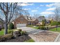 Brick home with a manicured lawn and a two-car garage; features dormer windows and a stone mailbox at 4930 Cecilia Sq, Cumming, GA 30040
