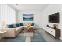 Bright living room with a large sofa, a wall-mounted TV, and modern decor at 5330 Willow Park Blvd, Atlanta, GA 30349