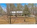 View of the home from the yard showcasing the exterior with mature trees at 303 Fireside Trl, Douglasville, GA 30134