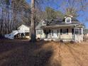 Quaint home featuring a covered front porch and adjacent guest house at 410 Invector Ct, Locust Grove, GA 30248
