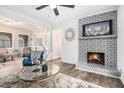 Bright living room featuring a fireplace, modern furniture, and hardwood floors at 6615 Buckhurst Trl, Atlanta, GA 30349