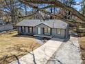 Inviting exterior view of a gray home with a long driveway and neat front lawn at 8329 Marlborough Dr, Jonesboro, GA 30238