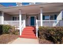 Inviting front porch with red stairs, white columns, and blue shutters for curb appeal at 105 Condor Ct, Woodstock, GA 30188