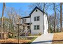 Side view of a charming two-story modern farmhouse with white siding, black trim and a concrete driveway at 2860 3Rd Sw Ave, Atlanta, GA 30315