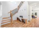 Bright foyer featuring hardwood floors, staircase with black metal railing, bench seating, and access to the living room at 2860 3Rd Sw Ave, Atlanta, GA 30315