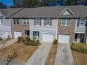 Townhome with blue siding, brick accents, and a single-car attached garage at 6338 Kinsland Ct, Lithonia, GA 30058