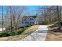 Beautiful two-story home with a long driveway surrounded by lush trees and landscaping at 4460 Wimberly Way, Cumming, GA 30028