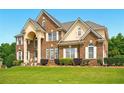 Stately two-story brick home with well-manicured lawn and symmetrical landscaping at 8056 Revere Dr, Mcdonough, GA 30252