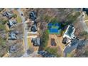 Aerial view showcasing homes, pool, tennis courts and playground within a beautiful neighborhood at 8424 Fairway Dr, Covington, GA 30014