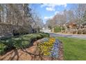Covington Place entrance with stone wall, sign, flower bed, manicured shrubs and grass at 8424 Fairway Dr, Covington, GA 30014