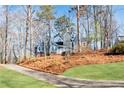 View of a gray two-story home surrounded by mature trees and a landscaped yard at 2421 Spring Lake Dr, Marietta, GA 30062
