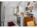 Well-lit kitchen featuring white cabinets, stainless steel dishwasher, and patterned tile floors at 885 Briarcliff Ne Rd # 16, Atlanta, GA 30306