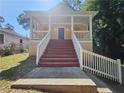 Exterior shot of the two-story home with a front porch, stairs, and green lawn at 1059 Sims Sw St, Atlanta, GA 30310