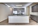 Open kitchen featuring stainless steel appliances, gray cabinets and a large granite island at 3802 Cedar Glade Ne Ln, Buford, GA 30519