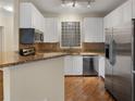 Bright kitchen with stainless steel appliances, granite countertops, and white cabinetry at 10 Perimeter Summit Ne Blvd # 2405, Atlanta, GA 30319