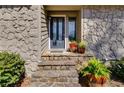 Charming front entrance features stone accents, a black door, and decorative potted plants at 3261 Turtle Lake Se Ct, Marietta, GA 30067