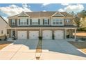 Exterior view of brick townhomes with attached garages and manicured lawns at 7207 Brigidoon Rose, Douglasville, GA 30134