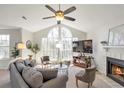 Bright living room featuring vaulted ceilings, large windows, a fireplace, and contemporary decor at 818 Dunes Way # 818, Alpharetta, GA 30022