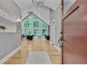 Grand foyer with soaring ceilings, hardwood floors, and expansive windows overlooking lush greenery at 1233 Poplar Grove Ne Dr, Atlanta, GA 30306