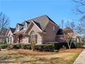 Beautiful home with a brick facade, well-maintained landscaping, and elegant architectural details under a bright blue sky at 8531 N Shore Dr, Jonesboro, GA 30236