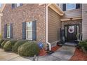 Close up showcasing the front door, flower wreath, and manicured landscaping in the front yard at 5156 Olive Branch Cir, Powder Springs, GA 30127