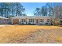 Single-story home with white brick, brown garage door, updated landscaping, and shuttered windows at , Tucker, GA 30084