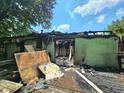 Back exterior view of the home with fire damage and debris on the ground at 2022 Cook Rd, Decatur, GA 30032