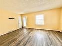 Living room featuring laminate wood flooring, yellow walls, and a glass door at 2022 Cook Rd, Decatur, GA 30032