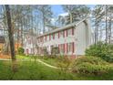 A lovely home with red shutters and beautiful landscaping, nestled among mature trees at 2086 Mountain Creek Ct, Stone Mountain, GA 30087