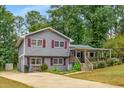 Well-maintained home with red shutters, a cozy front porch, and a spacious driveway at 3989 Woodland Se Cir, Conyers, GA 30013