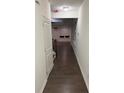 Hallway with dark wood floors leading to a room with a large window and white blinds at 4353 Morning Vw, Stone Mountain, GA 30083