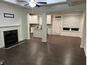 Open living room with fireplace, white trim, and hardwood floors flowing into the kitchen at 4353 Morning Vw, Stone Mountain, GA 30083