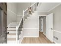 Bright foyer featuring a staircase with black iron railings and wood flooring at 5427 Fieldgreen Dr, Stone Mountain, GA 30088