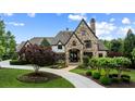Beautiful stone home featuring arched entry, custom driveway and manicured landscaping at 938 Crescent River Pass, Suwanee, GA 30024