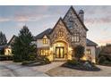 Majestic stone facade with an arched entry, double doors, and manicured landscaping at 938 Crescent River Pass, Suwanee, GA 30024